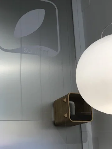 Wooden dumbwaiter next to spherical lamp and Amit Bhardwaj logo — connection between counter and workshop