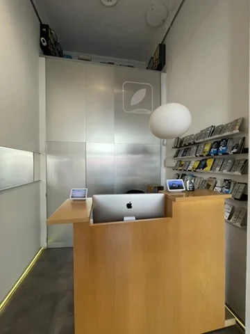 Amit Bhardwaj iRepair interior — what the customer sees walking in: counter with iMac, logo and spherical lamp